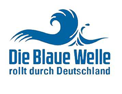 Blauer Die Blaue Welle rollt durch Deutschland Schriftzug mit einer abgebildeten blauen Welle.